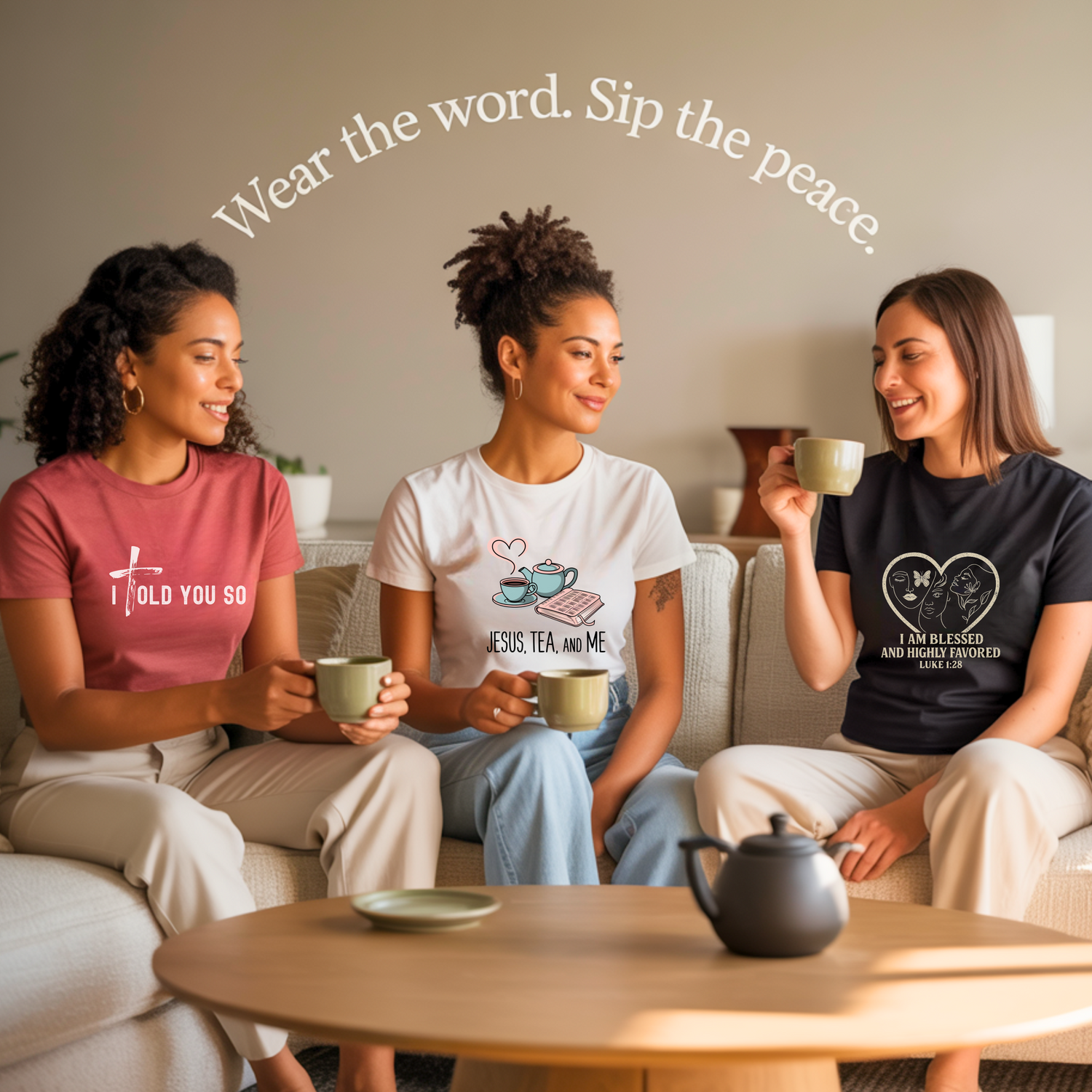 Three women sitting on a beige couch enjoying tea together, wearing Christian-themed t-shirts. The woman on the left wears a coral shirt with 'I TOLD YOU SO' and a cross, the middle woman wears a white shirt with 'JESUS, TEA, AND ME' with teacup graphics, and the woman on the right wears a black shirt with 'I AM BLESSED AND HIGHLY FAVORED LUKE 1:28' in a heart design. Text overlay reads 'Wear the word. Sip the peace.' A wooden coffee table with a teapot is visible in the foreground.